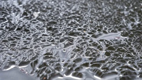 Dropping piece of ice splashing on melting ice cover Stock Footage 98129593