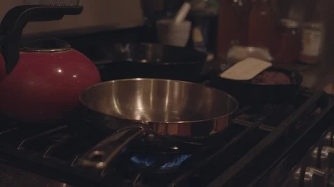 Dropping a pork chop onto a hot pan with oil, creating a splash. Stock Footage 86568657