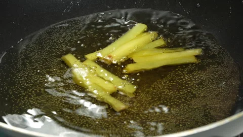 Dropping Potato Strips into Boiling Hot Oil Pan Stock Footage 343943671