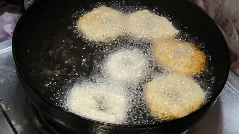 Dropping raw batter into hot oil to fry tootu vada close up Stock Footage 336061729