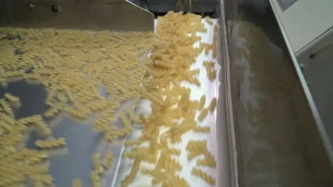 Dropping raw macaroni on a conveyor belt at the pasta factory Stock Footage 153476154