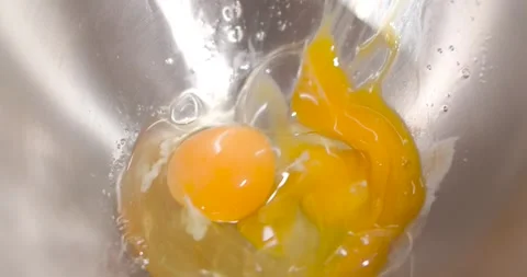 Dropping a second egg into a metal bowl. Stock Footage 262668665