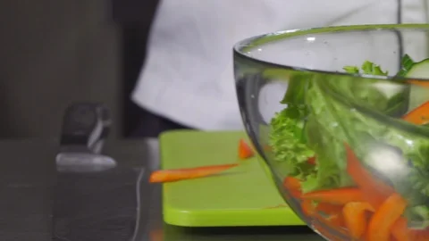 Dropping sliced cucumbers into salad in slow motion Stock Footage 127854934