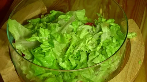 Dropping spices over  vegetarian salad by woman hand in home kitchen Stock Footage 231897331