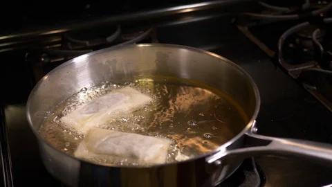 Dropping Spring Rolls in Oil Stock Footage 128402695