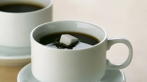 Dropping sugar cube into coffee, Slow Motion Stock Footage 12564789