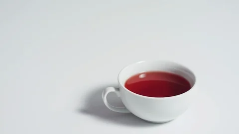 Dropping a sugar cube into a cup of tea Stock Footage 99754151