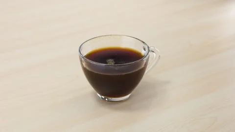 Dropping Sugar Cube into Glass Cup of Black Coffee Stock Footage 343842052