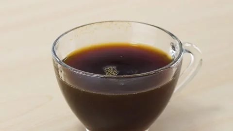 Dropping a Sugar Cube into a Glass Cup of Black Coffee Stock Footage 343842090