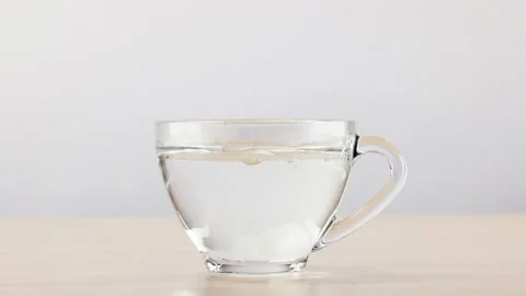 Dropping Sugar Cube into Glass Cup of Hot Water Stock Footage 345103114