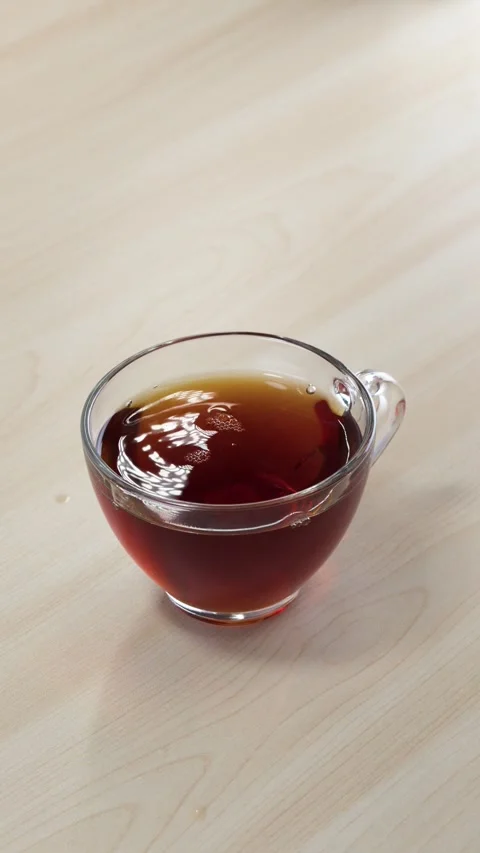 Dropping Sugar Cubes into Glass Cup of Black Tea with Metal Tongs Stock Footage 345693635