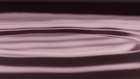 Dropping thin stream striking glossy deep maroon pool on table forming mound and Stock Footage 339722022