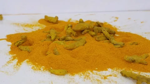 Dropping turmeric seed over heap of turmeric powder Видео 147696678