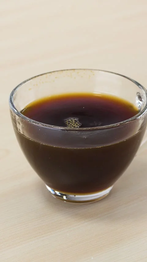 Dropping a White Sugar Cube into a Glass Cup of Black Coffee Stock Footage 344619767