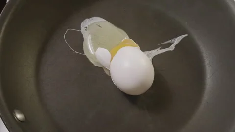 Dropping Whole Egg into hot pan in slow motion 스톡 동영상 131275362