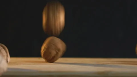 Dropping Whole Walnuts one by one. Black background Stock Footage 168155793