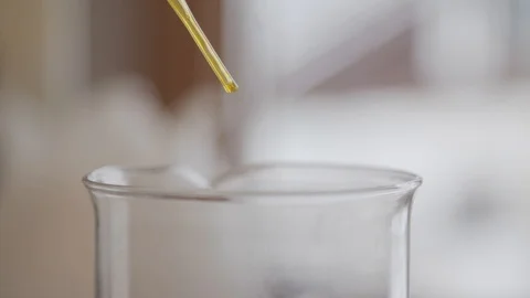 Dropping Yellow Liquid with Pipette into Container 動画素材 111757161