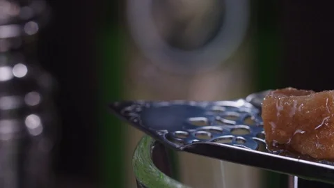 Drops of absinthe drip onto a piece of brown sugar. Close-up Stock Footage 129008257