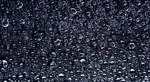 Drops align on dark background plane. Drops create strong background texture Stock Photos