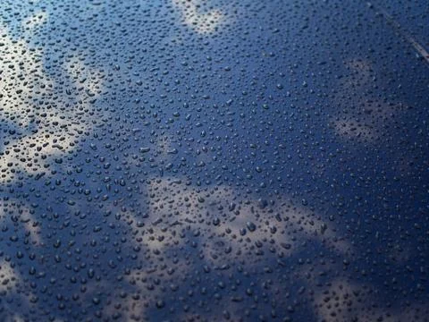Drops and cloudy sky reflection on the metal surface Stock Photos