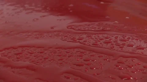 Drops and water flows on red surface Stock Footage