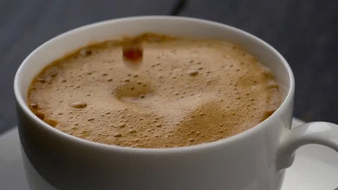 Drops of coffee are falling into espresso cup. Slow motion shot. Stock Footage 86010321