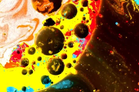 Drops of colored paint in milk in a macro shot Stock Photos