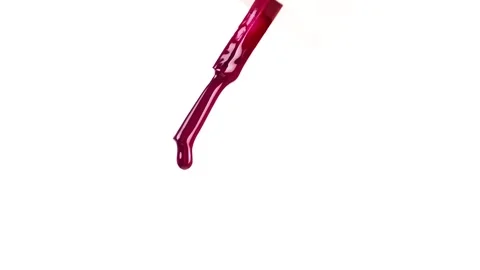 Drops of deep red nail polish falling from a brush, macro. Stock Footage 304461528