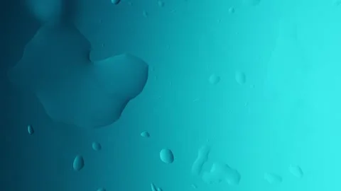 Drops drip from above and scatter across a light blue gradient background Видео 303060961