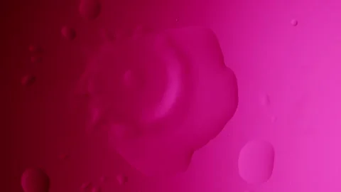 Drops drip from above and scatter on a pink gradient background 動画素材 303061152