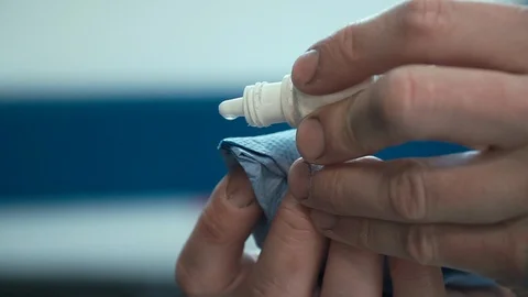 Drops drip from a plastic bottle onto a napkin. Macro flacon vial, flask, phial Stock Footage 111327493