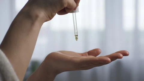 Drops of face massage oil flow from the pipette onto the palm of the hand. Stock Footage 267212780