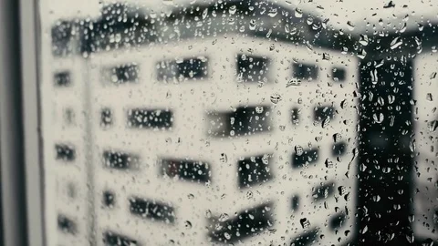 Drops fall and roll on the glass closeup shot with building outside Video stock 73912723