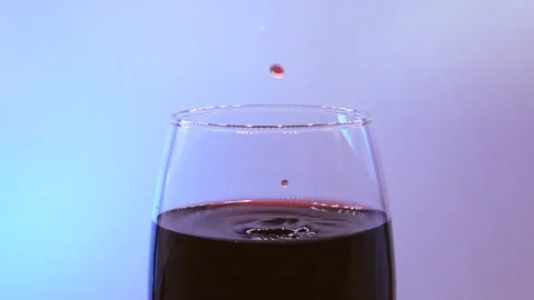 Drops fall into glass with red wine in slow motion Video stock 146748047
