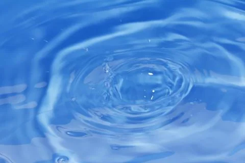 Drops fall into the water. beautiful background Stock Photos