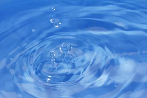 Drops fall into the water. beautiful background Stock Photos