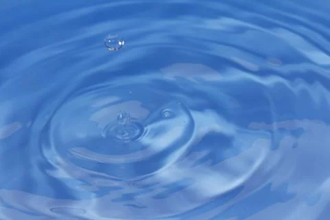 Drops fall into the water. beautiful background Stock Photos