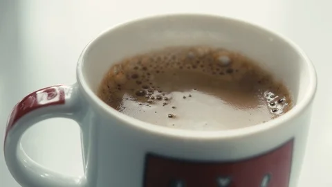 Drops falling in a cup of espresso in slow motion. Stock Footage 97236293