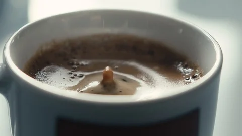 Drops falling in a cup of espresso in slow motion. Stock Footage 97236298