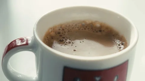 Drops falling in a cup of espresso in slow motion. Stock Footage 97236301