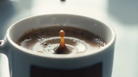 Drops falling in a cup of espresso in slow motion. Stock Footage 97236317