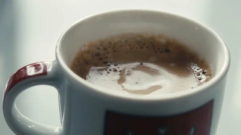Drops falling in a cup of espresso in slow motion. Stock Footage 97236332