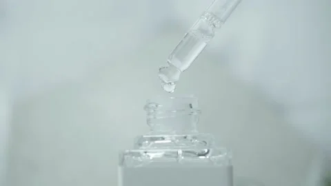 Drops falling from pippet to little glass bottle Stock Footage 205581391