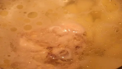 Drops of fat float on the surface of hot chicken bouillon Stock Footage 98293960