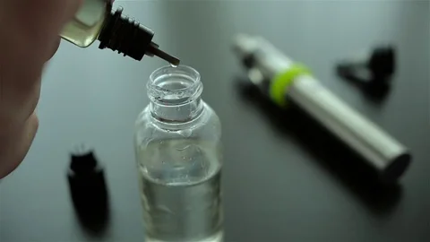 Drops of flavor into the liquid for electronic cigarette for background. Stock Footage 72414740