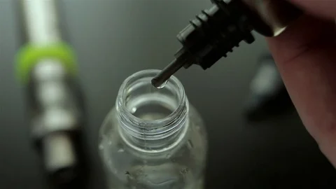 Drops of flavor into the liquid for electronic cigarette for background. Stock Footage 72414761