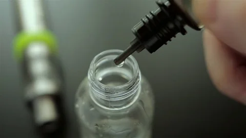 Drops of flavor into the liquid for electronic cigarette for background. Stock Footage 72414774