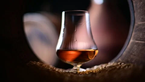 Drops flow down a glass of bourbon whiskey Stock Footage 279557382