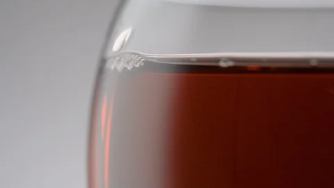 Drops flow down the surface of a glass of red wine Stock Footage 123905465