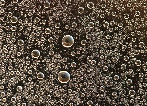 Drops on glass of different sizes and colors on a colored background, texture Stock Photos